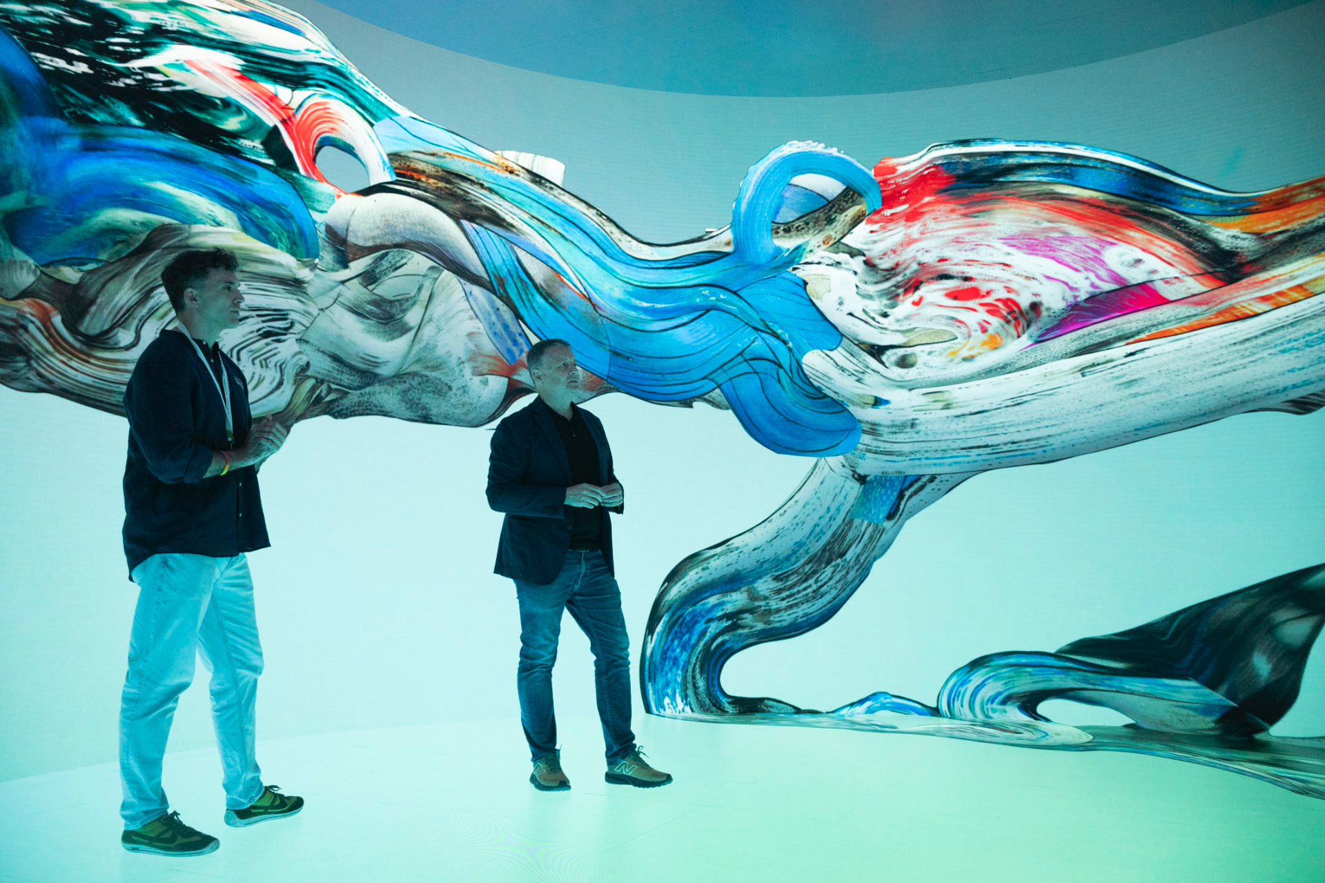 Dos visitantes en el espacio digital inmersivo Vortex, rodeados de flujos visuales generados por los datos del mar