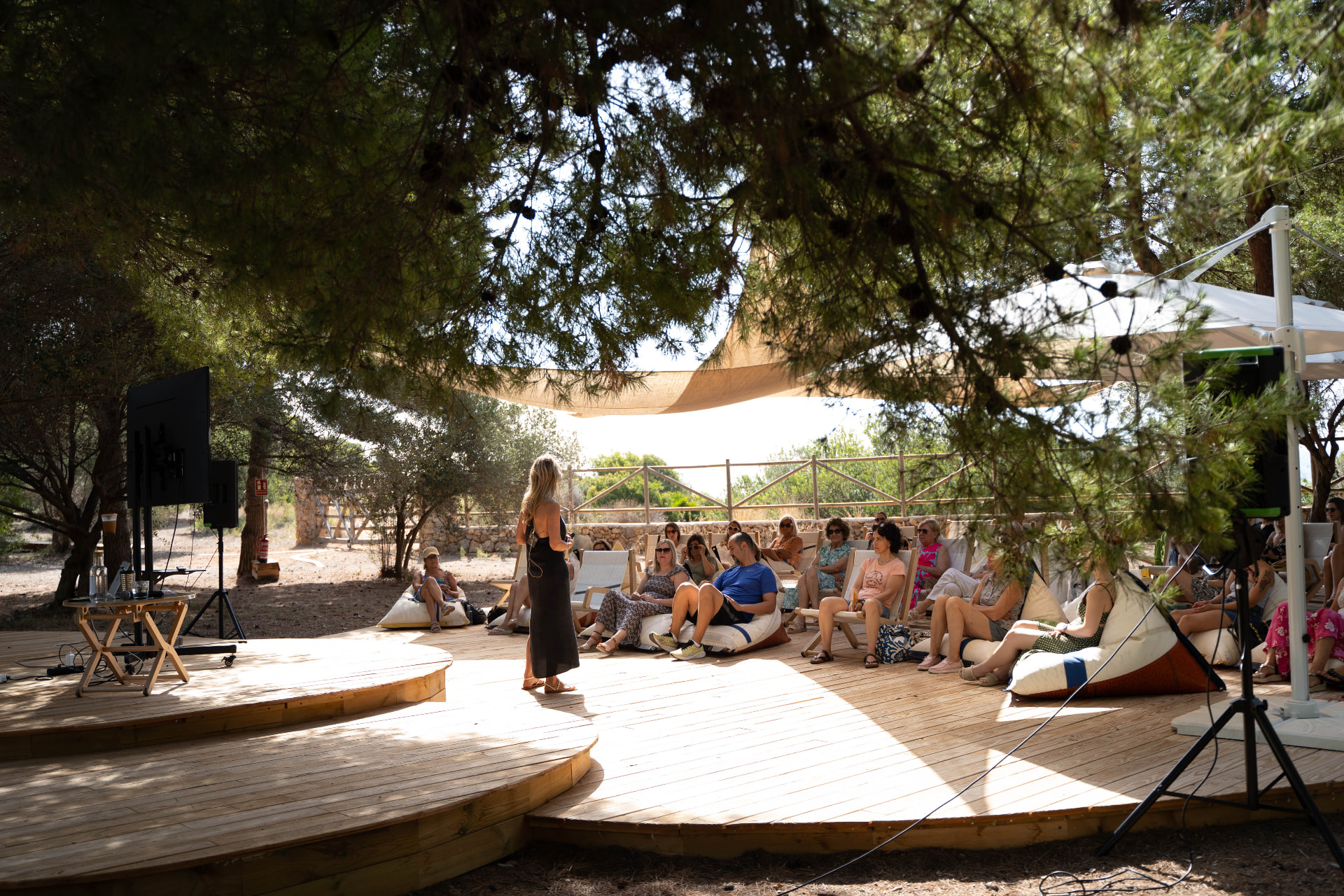 Charla de bienestar ante el público en la plataforma circular de Bosque Masía Bellver