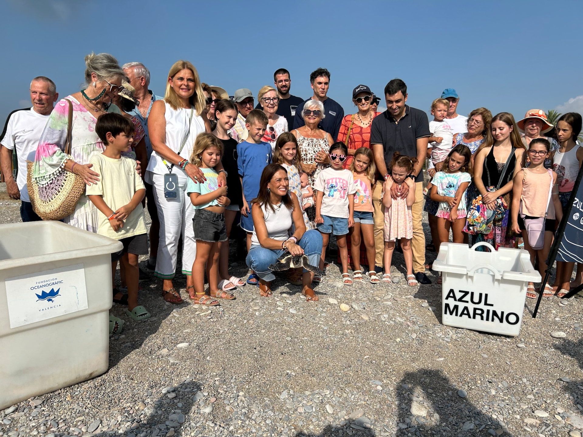 Foto de grupo de los asistentes a la suelta junto a los cajones de la Fundación Azul Marino y la Fundación Oceanogràfic