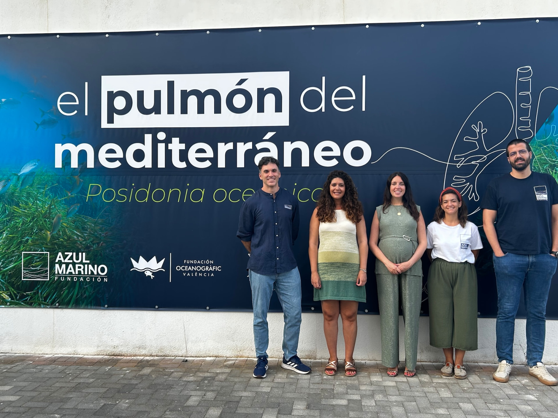 Representantes municipales y equipo de la Fundación Azul Marino ante la lona de la campaña