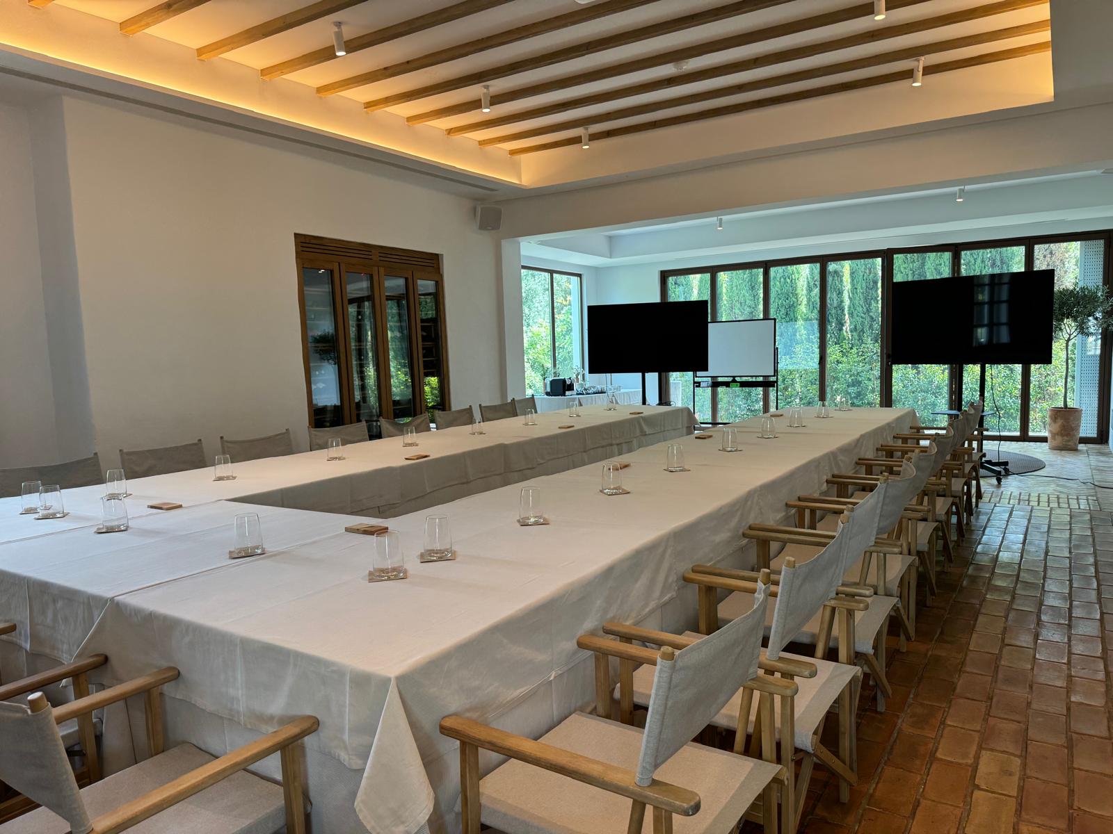 sala de reuniones para un evento híbrido con mesa y elementos de telecomunicación